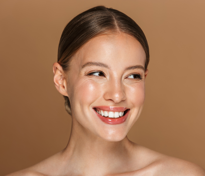 Lächelnde junge Frau nach Faltenbehandlung mit Botox