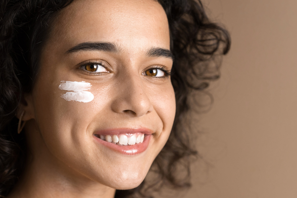 nachsorge Frau mit Sonnencreme im Gesicht.